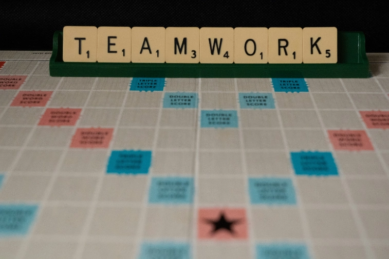 set de lettres de scrabble sur leur support écrivant le mot 'teamwork'