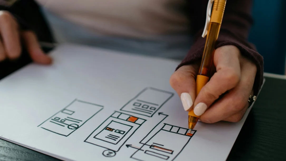 Photo d’une développeuse dessinant l’arborescence d’un site web professionnel, illustrant la conception sur-mesure et la réflexion stratégique pour créer une vitrine digitale efficace.